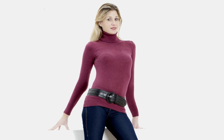 Woman wearing a belt on top of a turtleneck sweater
