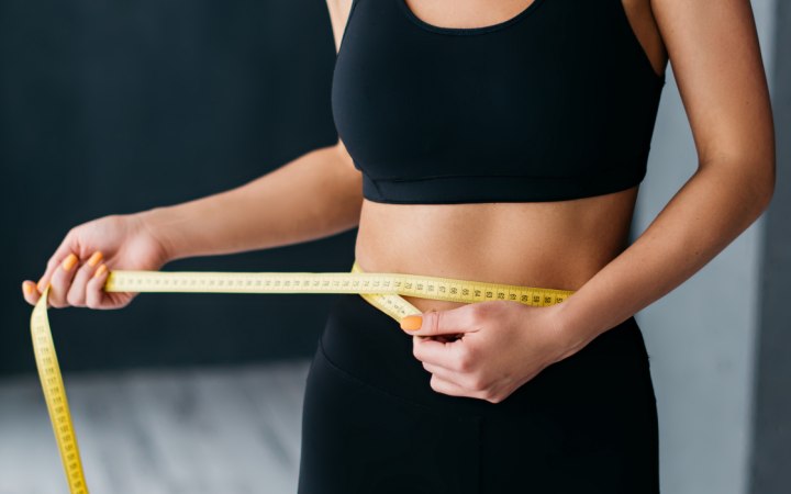 Woman who is measuring her waistline