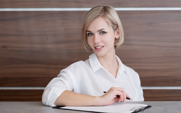 Professional woman with short hair and a white buttoned shirt