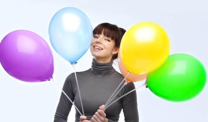 Woman wearing an unfolded shiny turtleneck collar and balloons of different colors