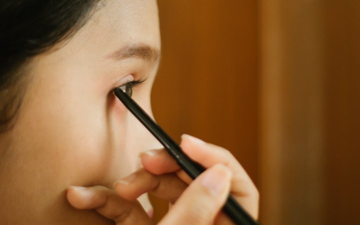 Applying eyeliner