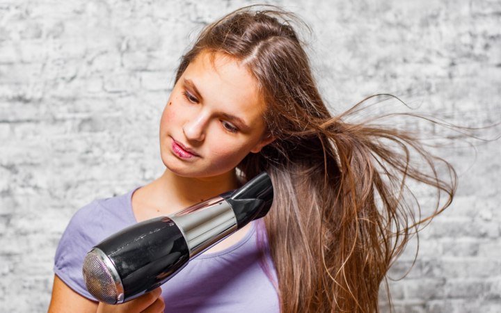 Girl who is blow drying her long hair
