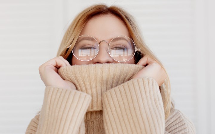 Woman who is hiding her face in a turtleneck