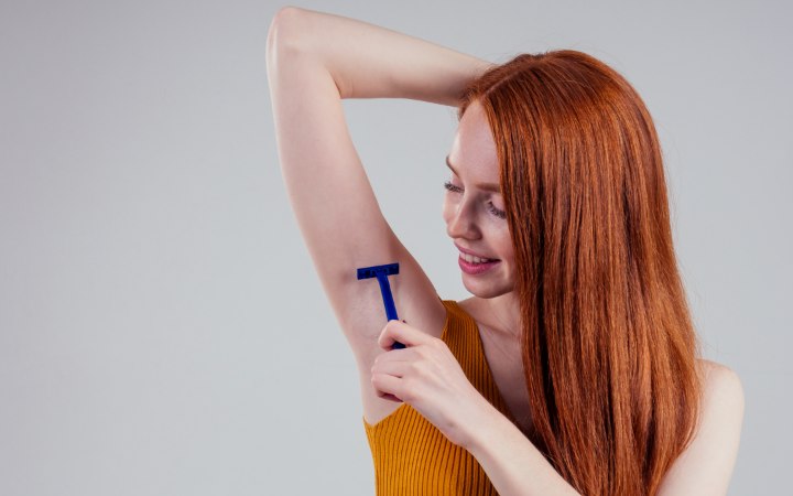 Woman who is shaving her armpits